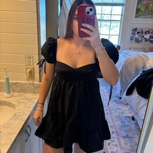 Olivaceous black mini dress with puffy sleeves and tie up straps. Size: S